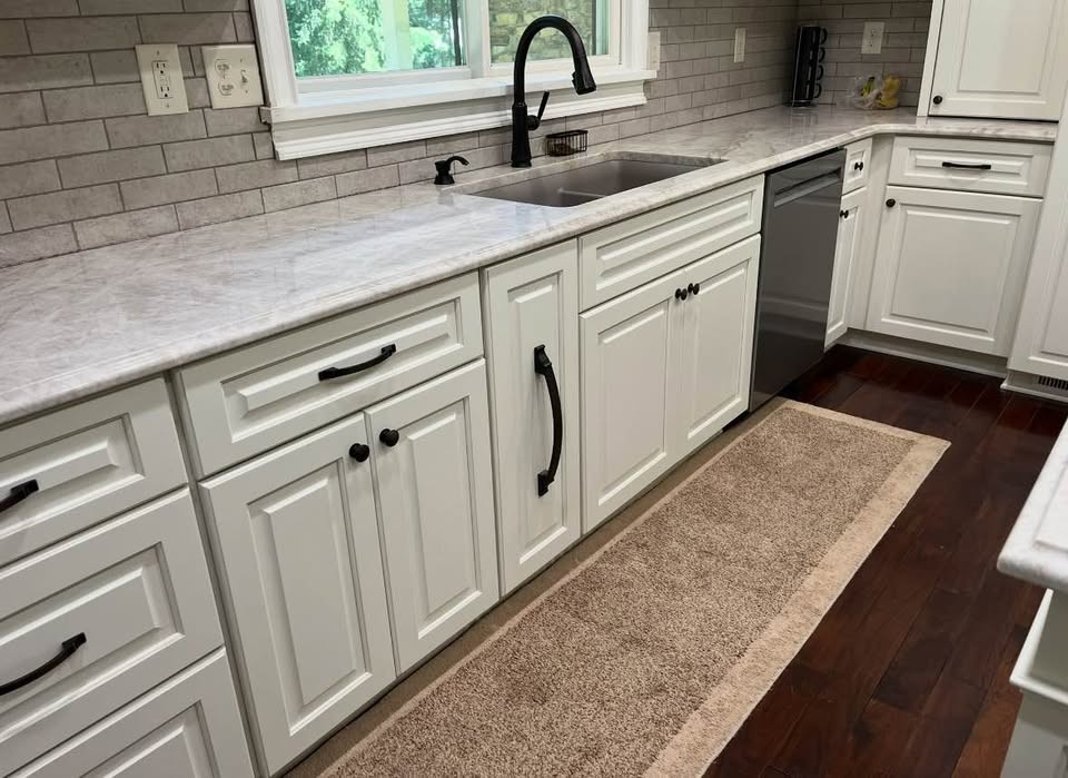 White raised-panel base cabinets along the sink wall