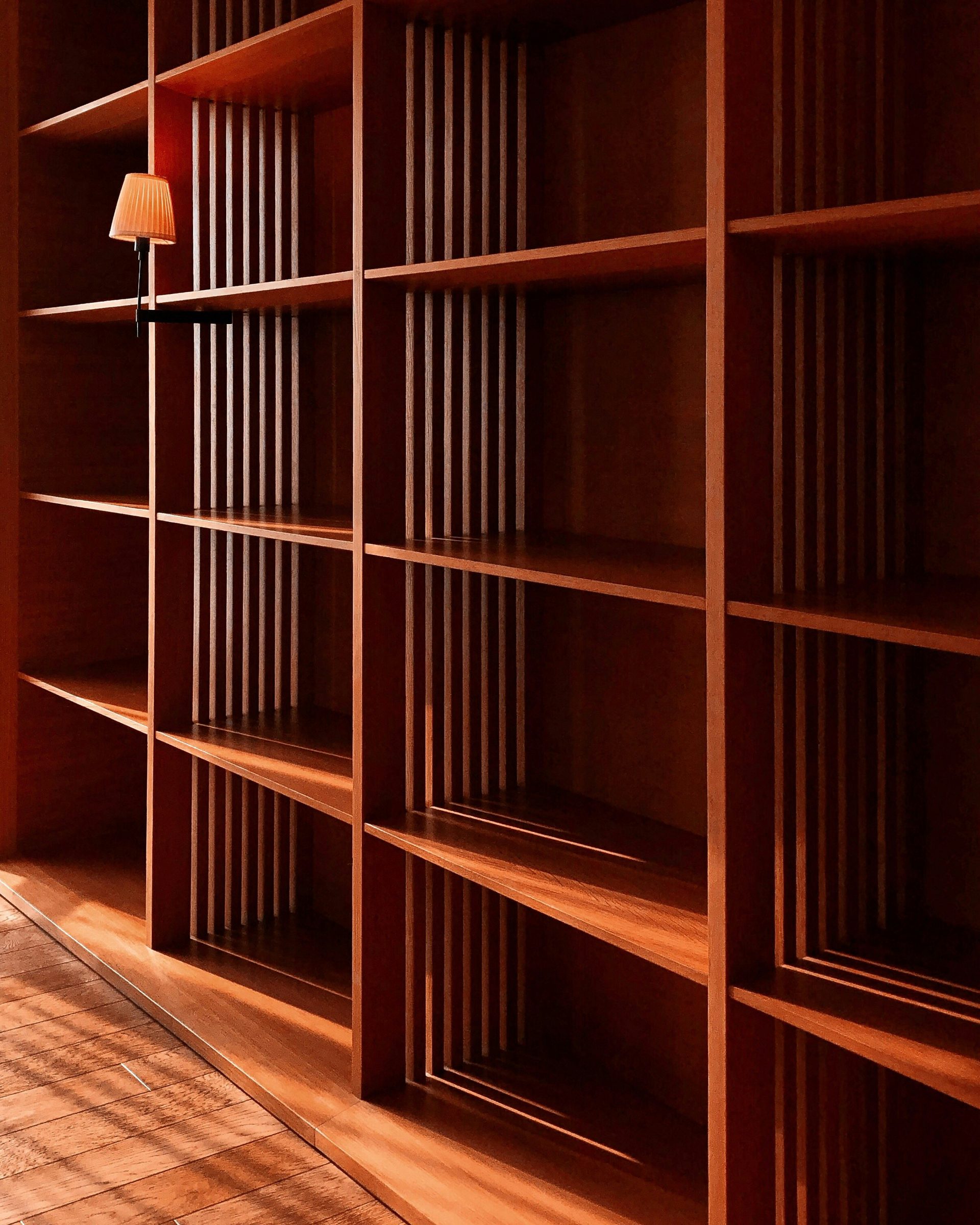 Warm walnut-toned open shelving built into a wall, shown close up